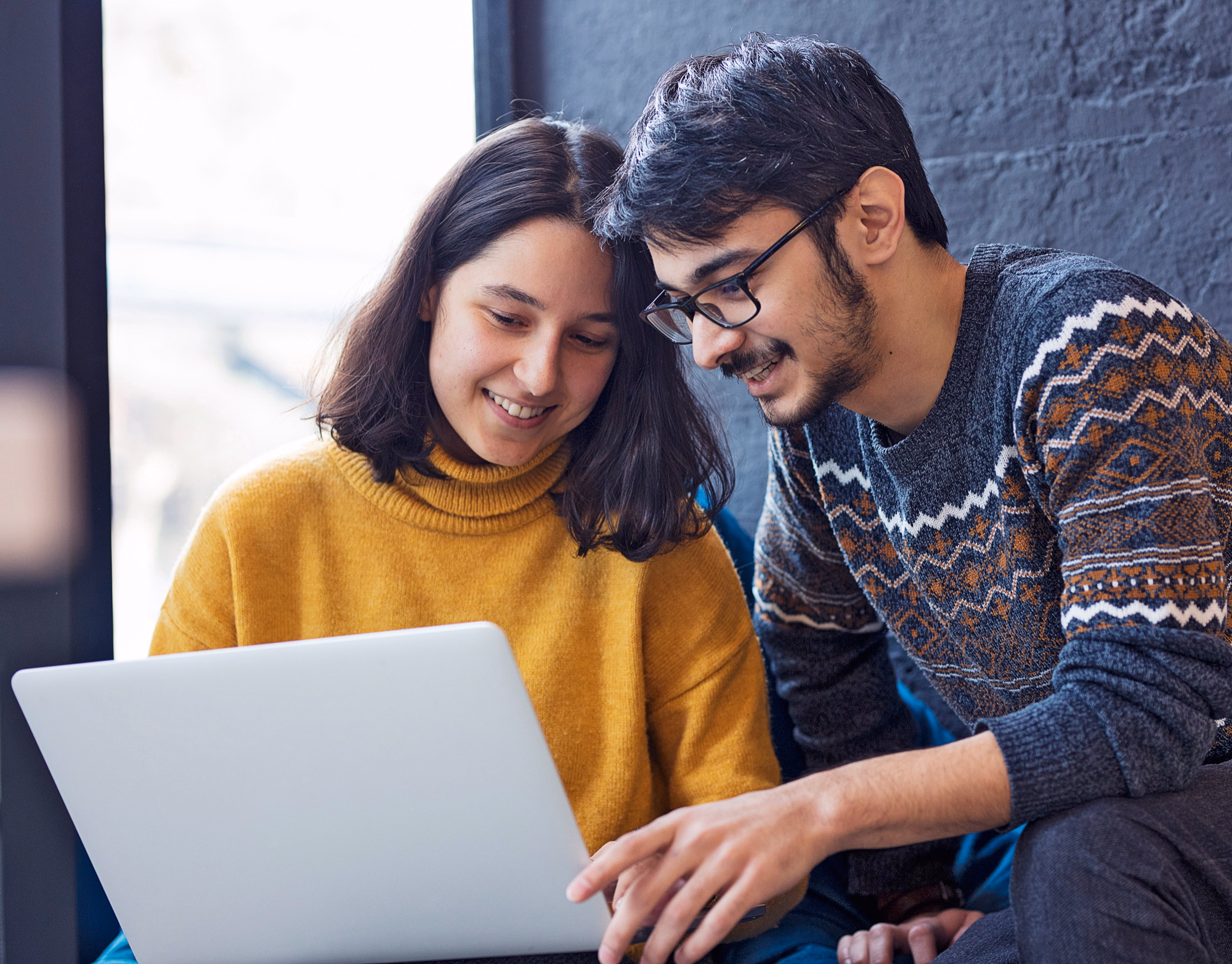 Gray sectional sofa with black coffee table and blue rug